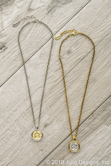 Two necklaces, one silver and one gold, on a wooden surface.