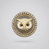 A hand holding a round owl face brooch with a gold-tone and cream enamel design, surrounded by a border of small clear rhinestones.